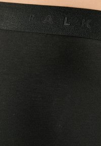 Zwarte leggings van textiel met een gestructureerde stof, voorzien van een donkere elastische tailleband met de geperste tekst "PALK." Gladde oppervlakte met een lichte glans.