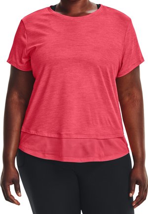 Kobieta ubrana w luźną czerwoną sportową bluzkę z krótkim rękawem i siateczkowym wykończeniem na dole oraz czarne spodnie, stoi z ramionami swobodnie zwisającymi wzdłuż ciała.