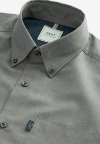 Hellgrau button-up Hemd mit Kragen, aus strukturiertem Stoff. Mit schwarzen Knöpfen, einer Brusttasche und einem gemusterten Innenfutter.