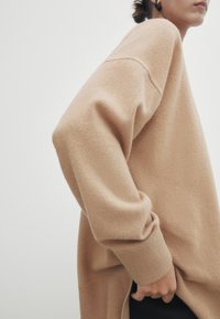 Ljust brunt Sverige tröja i mjukt tyg, med en avslappnad passform, sänkta axelsömmar och ribbade muddärmar. Sidoklyfta för att underlätta rörelse.