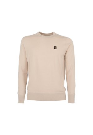 Suéter de cuello redondo de manga larga color beige con puños y dobladillo acanalados, que presenta un pequeño parche de logo negro y dorado en el lado izquierdo del pecho.