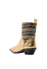Botas de tobillo de cuero dorado con un empeine tejido colorido y texturizado, tacón cuadrado corto, punta afilada y tachuelas decorativas a lo largo del costado.