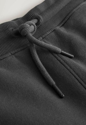Gray sweatshirt fabric with a ribbed waistband. Features a braided drawstring and black plastic aglets for adjustment.