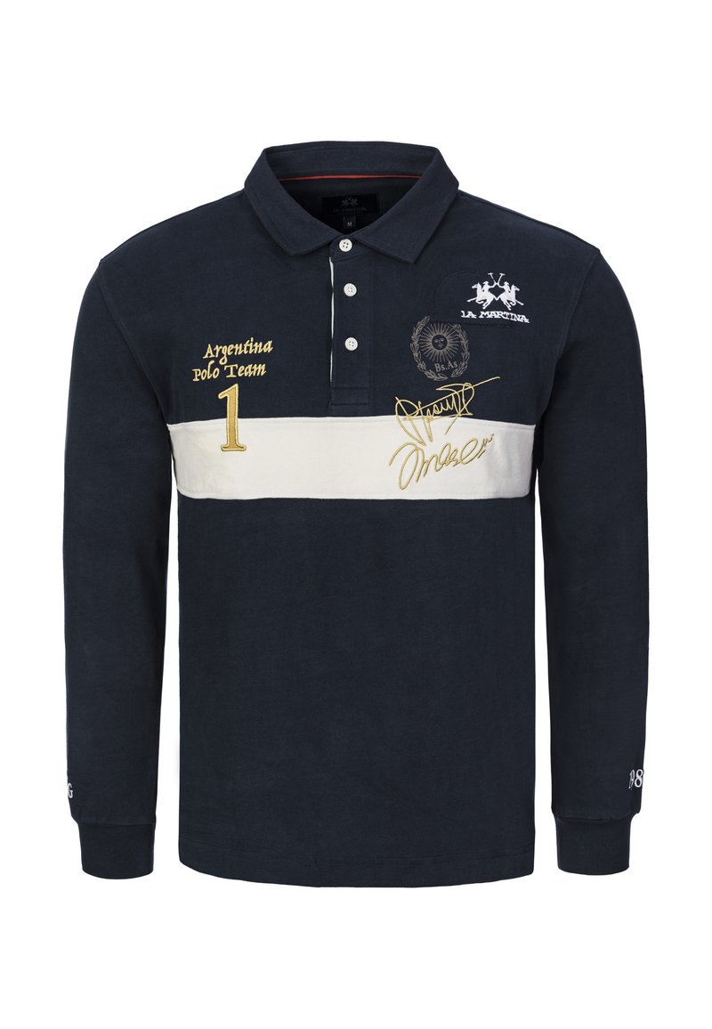 Marinblå pikétröja med lång ärm, med en vit horisontell rand, broderad logotyp, gulddetaljer och en knäppning med tre knappar.