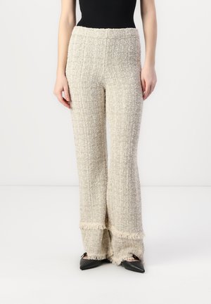 Tweed flared pants in cream with a textured weave, featuring a fringed hem and a high, elastic waistband for a comfortable fit.