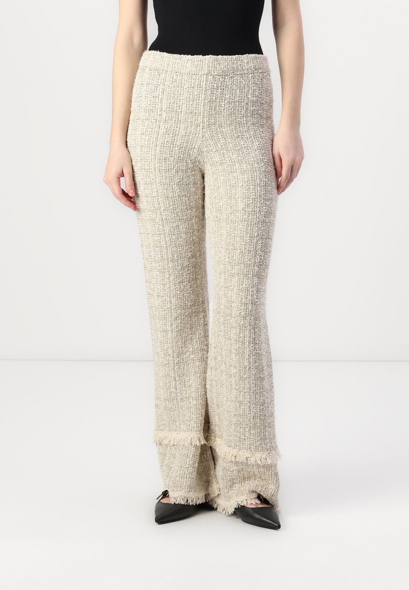 Tweed flared bukser i creme med en tekstureret vævning, der har en frynset kant og en høj, elastisk talje for en behagelig pasform.
