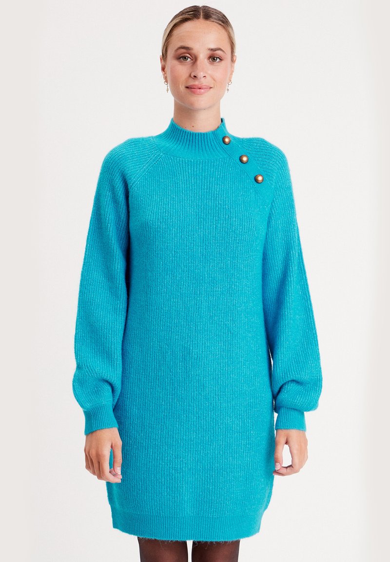 Türkises Strickkleid mit hohem Kragen, langen Puffärmeln, gerippter Textur und drei dekorativen goldenen Knöpfen an der Schulter.