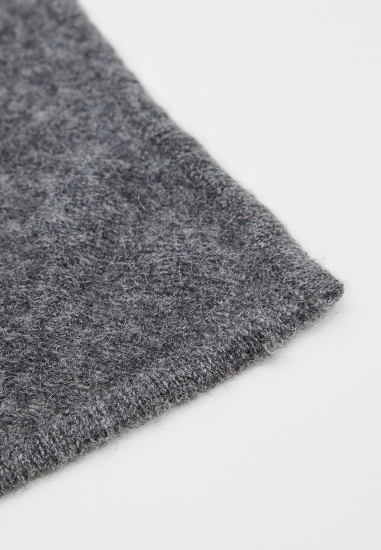 Grau wollstoff zeigt eine weiche, flauschige Textur mit einem leicht gerippten Rand, der subtile Farbvariationen und eine saubere Verarbeitung aufweist.