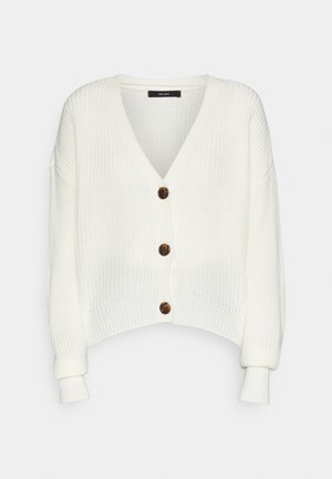 White cropped cardigan made of textured knit, featuring a deep V-neck, long sleeves, and five brown buttons down the front.