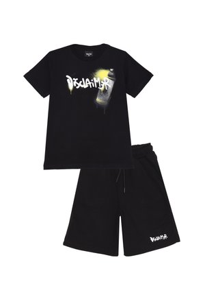 T-shirt nera in cotone con testo "Disclaimer" in stile graffiti bianco e grafica di una bomboletta spray. Abbinato a pantaloni corti neri con accenti del logo.