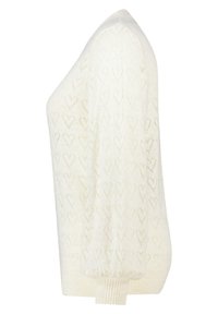 Pull en tricot couleur écrue avec un motif en forme de cœur, manches longues et poignets côtelés. Texture légère et coupe ample.