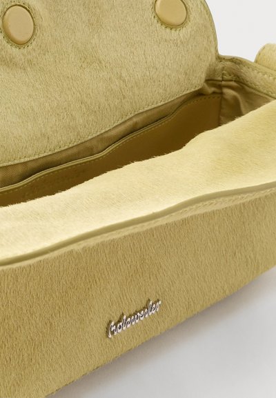 Žltá kabelka s textúrou, magnetickým zapínaním, viditeľnou vnútornou priehradkou a malým strieborným logom značky na prednej strane.