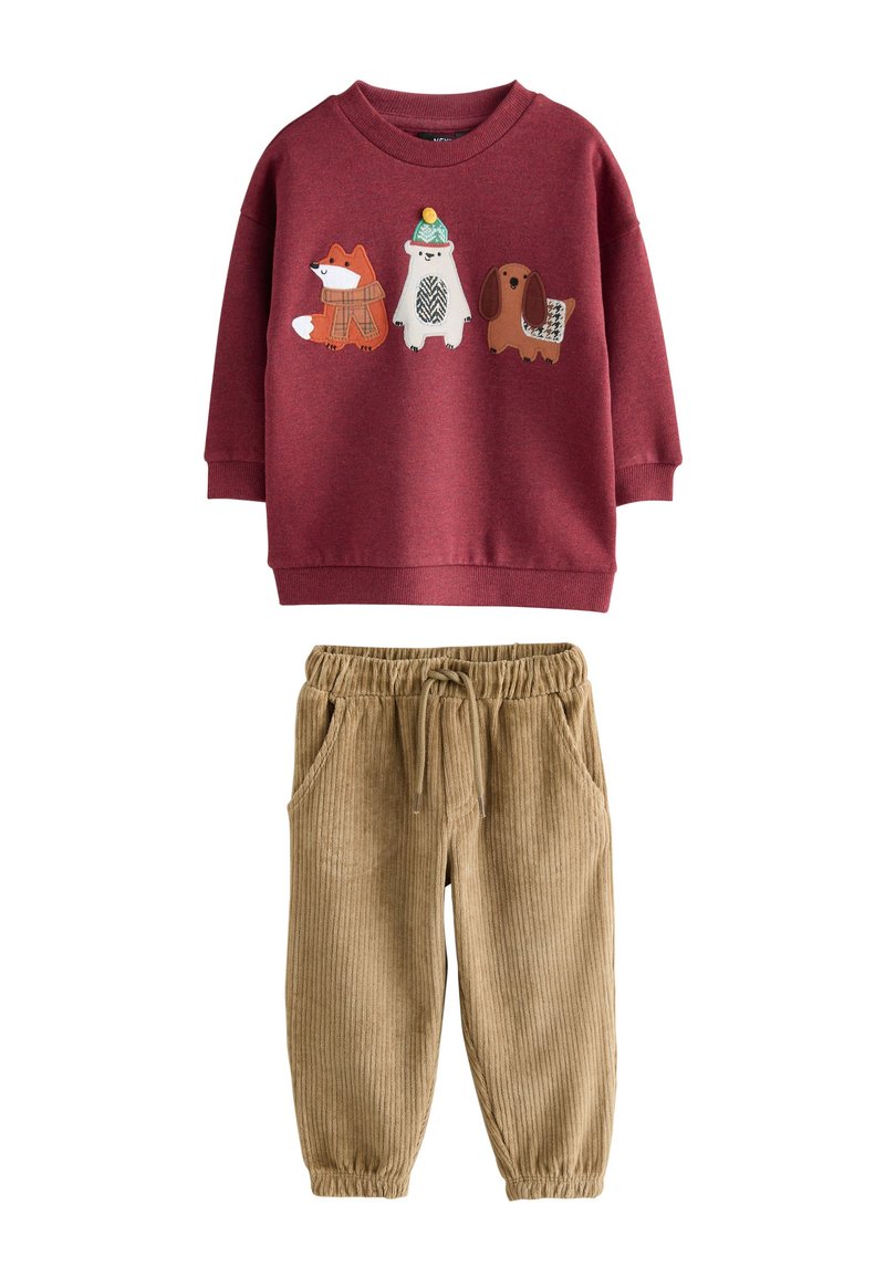 Sweat-shirt rouge avec appliqués d'animaux (renard, ours, chien) et poignets côtelés, associé à un jogging en velours côtelé beige avec taille élastique et poches.