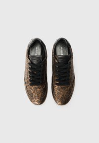 Baskets à imprimé léopard marron avec des accents noirs, surface texturée, bout rond et lacets noirs. Logo de la marque visible sur la languette.