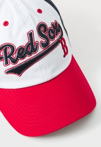Beisbola cepure ar sarkanu mali un baltu kroni, izšūts "Red Sox" logo melnā un sarkanā krāsā, ar izliekamu vizieri.