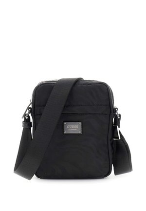 Zwarte rechthoekige crossbodytas met verstelbare riem en metalen logoplaatje aan de voorkant met de tekst "GUESS Los Angeles".