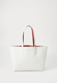 White tote bag with red accents, textured exterior, long handles, and a simple design. Interior features a patterned lining.