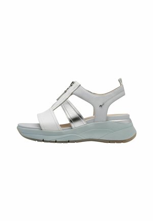 Sandale blanche avec accents argentés, brides ajustables, semelle intermédiaire rembourrée bleu clair, semelle extérieure texturée et fermeture éclair sur le côté.