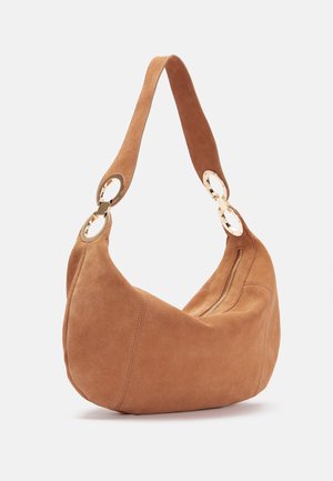 Sac à épaule en daim marron avec une large bandoulière fixée par des anneaux circulaires dorés et un détail de fermeture éclair sur le côté.