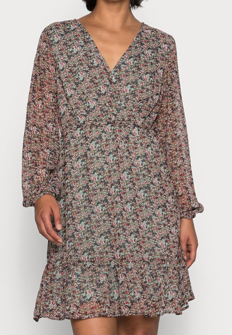 Květinové šaty s hlubokým výstřihem do V, dlouhými rukávy a vrstvenou sukní. Vyrobené z lehkého materiálu v zelených, červených a béžových odstínech.
