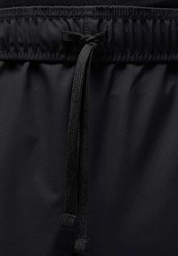 Zwarte elastische tailleband met een verstelbaar koord. Zachte, gladde stoftextuur met minimale glans en geen zichtbare patronen.