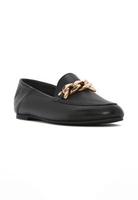 Mocassino in pelle nera con punta affusolata, dotato di un accento in catena dorata sul davanti. Texture liscia con dettagli di cucitura minimi.