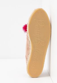 Semelle d'une espadrille rose avec détail pompon rouge, indiquant la marque "Pretty Ballerinas", taille 37, et l'inscription "Made in Spain".