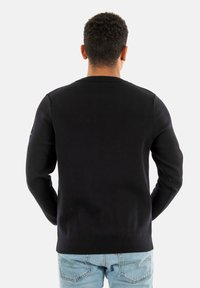 Maglione nero da uomo in maglia con scollo tondo e maniche lunghe, caratterizzato da una texture liscia e un design aderente.