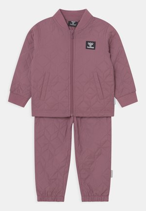 Lilla quiltet jakke og bukser sæt med lynlås foran, elastiske manchetter, to sidelommer og et logo patch på jakken.