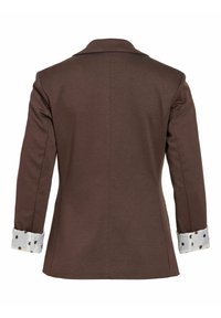 Blazer marron à manches longues avec col, vu de dos, avec des poignets blancs à gros pois marron repliés sur les manches.