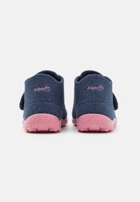 Blå filtskor med en rosa prickig sula och rosa "superfit"-logotyp. Har en robust design och mjuk textur för komfort.