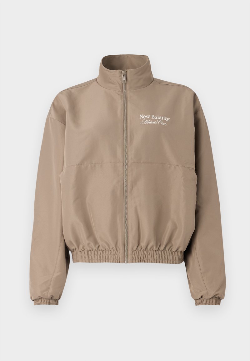 Veste coupe-vent beige avec un col haut, des poignets élastiques et un ourlet inférieur. Comprend une fermeture éclair à l'avant et un logo "New Balance Athlete Club".