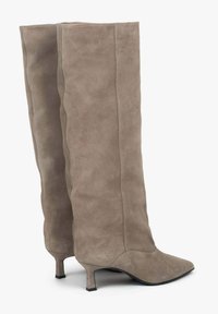 Semišové hnědé vysoké boty s špičatou špičkou a nízkým podpatkem. Vyznačují se vlnitou texturou po stranách a hladkou podrážkou.