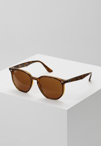 Ochelari de soare tortoise brown cu rame rotunde, lentile nuanțate de brun și accente argintii pe brațe. Design clasic, material din plastic.