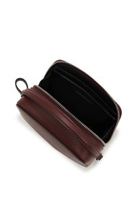 Burgundy leather pouch with zip closure, featuring an interior pocket and multiple card slots. Smooth texture and minimalist design.