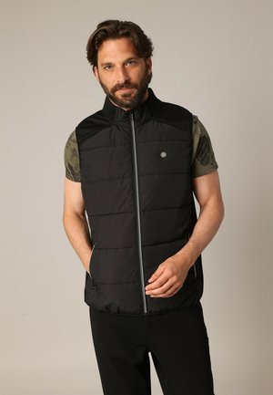 Zwarte, mouwloze puffer vest met een ritssluiting aan de voorkant, opstaande kraag en gewatteerd ontwerp. Voorzien van een logopatch op de borst en zijzakken.