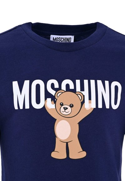 Marineblauwe t-shirt met een beerafbeelding en het woord "MOSCHINO" in vetgedrukte witte letters. Katoenen stof met een ronde hals.
