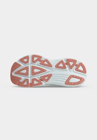 Semelle de chaussure blanche avec des motifs de grip en caoutchouc rose et le nom de la marque Saucony embossé au centre.
