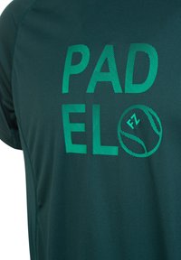 Mörkgrön idrottströja med "PADELO" i fet, randig turkos bokstäver och en tennisboll med "FZ"-detalj. Slät textur, korta ärmar.