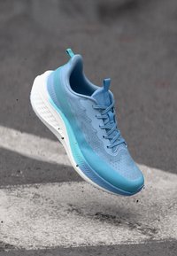 Hele helesinine jooksujalanõud, millel on hingav pealis, tekstuursed mustrid, pehmendusega krae ja valge vaheplaat, loodud mugavuseks ja jõudluseks.