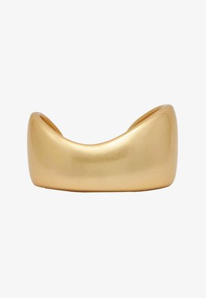 Tykt, glat, skinnende guldbredt armbånd med et bredt, buet, hul design og afrundede kanter på en hvid baggrund.