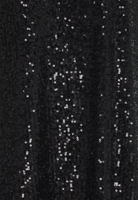 Tissu noir densément recouvert de petites paillettes noires brillantes reflétant la lumière en motifs épars.