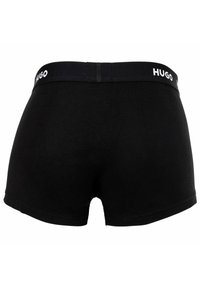 Schwarze Boxershorts aus weicher Baumwolle mit breitem elastischen Bund, der das „HUGO“-Logo in Weiß trägt. Glatte Textur und enganliegendes Design.