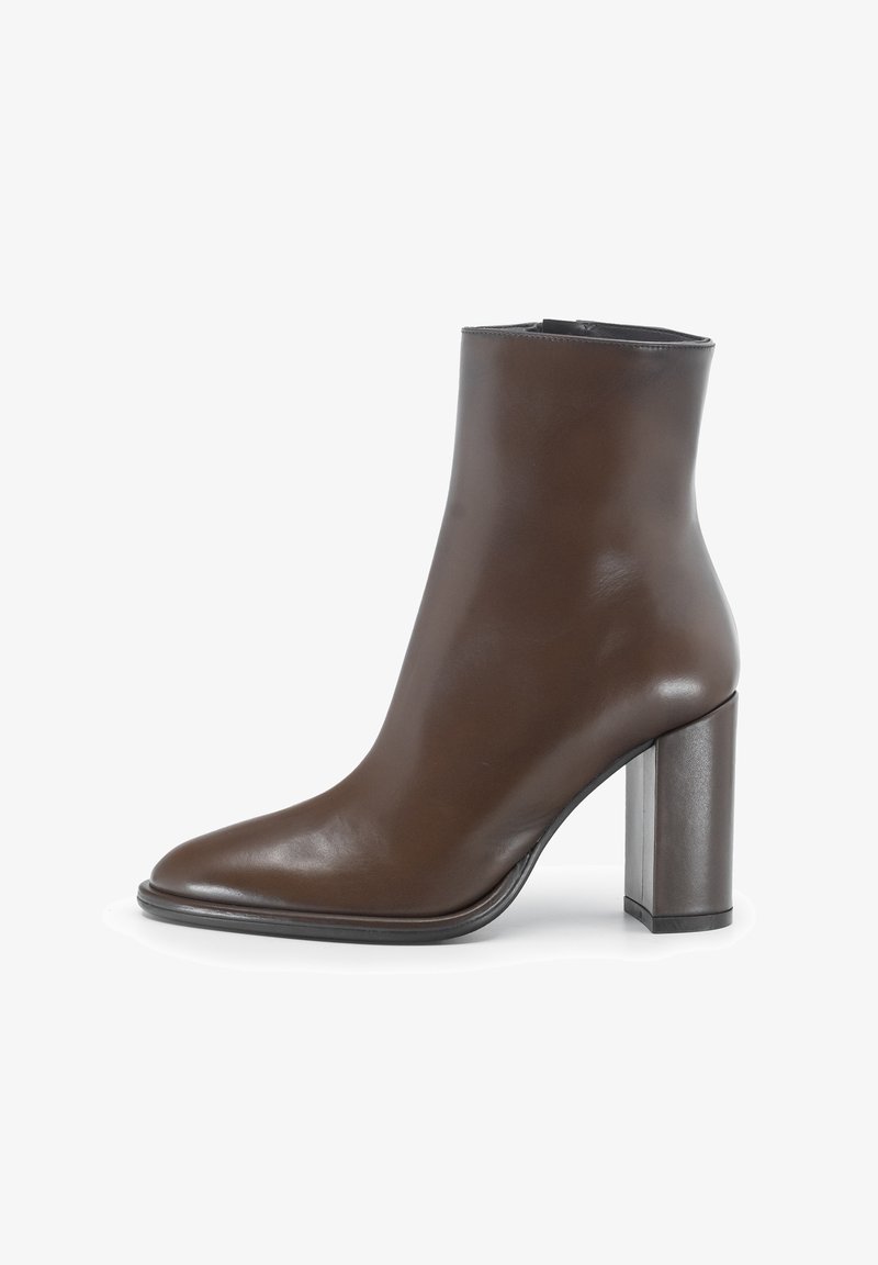 Stivale in pelle marrone con punta affusolata, gambale stretto e tacco a blocco alto. Texture liscia con pochi dettagli di cucitura.