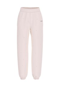 Lichtroze joggers van zacht materiaal met een elastische tailleband, taps toelopende boorden en verspreide zwarte stipaccenten. Bevat branding aan de zijkant.