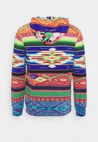 Bunte Kapuzenjacke mit lebhaften horizontalen Streifen und geometrischen Mustern in Rot, Grün, Blau und Orange, mit floralen Details an der Kapuze.