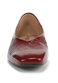 Ballerina in vernice rossa con punta arrotondata, superficie texturizzata e profilo basso. Rivestimento interno liscio con un delicato dettaglio delle cuciture.