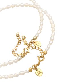 Halskette aus weißen Süßwasserperlen mit einer goldenen Kette, einem Verschluss und zwei goldenen Akzent-Tags, die ein Logo tragen. Die Perlen haben eine glatte, glänzende Textur.