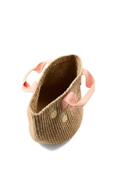 Wiklinowa torba na ramię z różowymi materiałowymi rączkami i małymi haftowanymi ananasami po boku, widziana z perspektywy z góry.