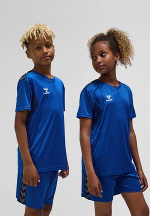 Blå atletisk tröja och shorts i mjukt, lättviktigt tyg. Har svarta detaljer på axlar och sidor samt en logotyp på bröstet.